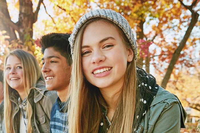 Young adults smiling outdoors in lifestyle image at Smile By Design Orthodontics in Durango, Cortez, and Pagosa Springs, CO